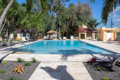 a swimming pool in a yard with palm trees at Parador Guánica 1929 in Guanica