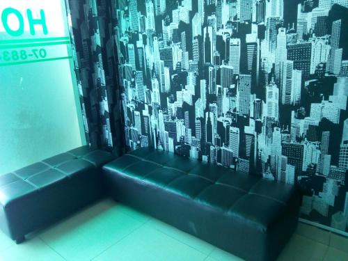 a black couch in a room with a city mural at BINKHALED HOTEL in Kota Tinggi