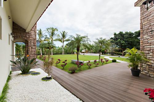 una pasarela de madera que conduce a un jardín con palmeras en Ai Ruo Mi B&B, en Chishang
