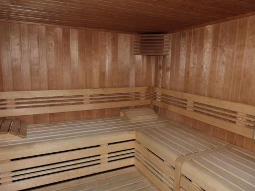 an empty sauna with wooden walls and benches at Residence Panorama in Villars-sur-Ollon