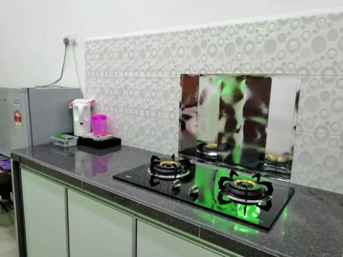 a kitchen with a green stove top oven at NAZ Homestay in Jitra