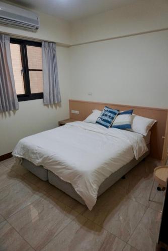 a bedroom with a bed with two pillows on it at Sumu X Sumu in Donggang