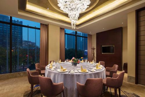 嘉定区にあるWyndham Shanghai Nanxiangのテーブルと椅子とシャンデリアのあるダイニングルーム
