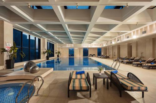 a pool in a hotel with chairs and a table at Wyndham Shanghai Nanxiang in Jiading