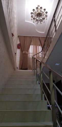 a staircase with a chandelier in a building at B&B Europa Hotel in Kutaisi