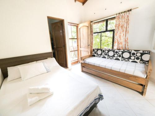 sypialnia z łóżkiem i oknem w obiekcie Punta Caribana Casa Hotel w mieście Necoclí
