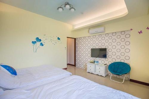 a bedroom with a bed and a tv and a chair at 綠竹筍民宿 in Zhushan