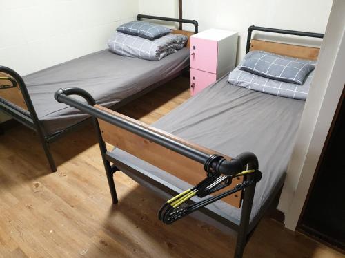 a bedroom with two beds and a chair at Able Guesthouse Hongdae 2 in Seoul