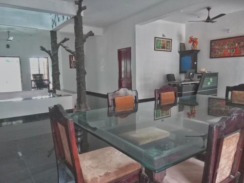 a dining room with a glass table and chairs at Vedic Heritage Boutique Hotel in Kovalam