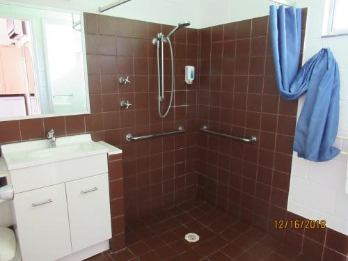 a bathroom with a shower, sink, and toilet at Moruya Motel in Moruya