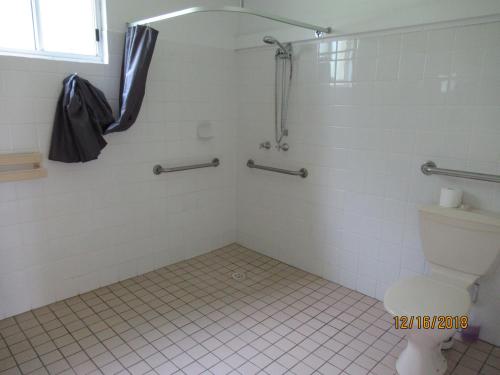 a bathroom with a shower and a toilet at Moruya Motel in Moruya