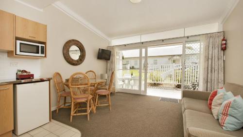 a kitchen and living room with a couch and a table at Hananui Lodge and Apartments in Russell