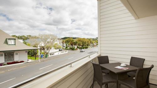 a balcony with a table and chairs and a street at Hananui Lodge and Apartments in Russell