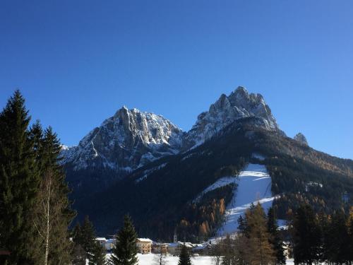 een bergketen met een meer op de voorgrond bij La Casa del Mulino in Pozza di Fassa