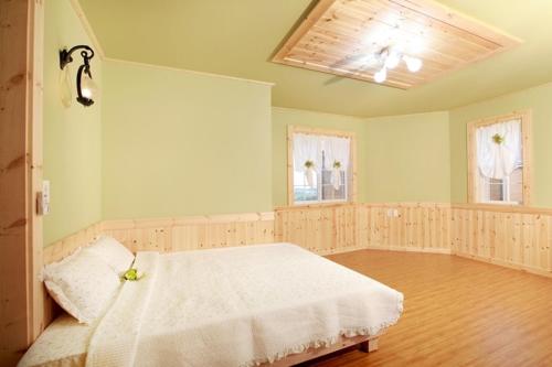 ein Schlafzimmer mit einem weißen Bett in einem Zimmer in der Unterkunft Sweetsalt in Seogwipo