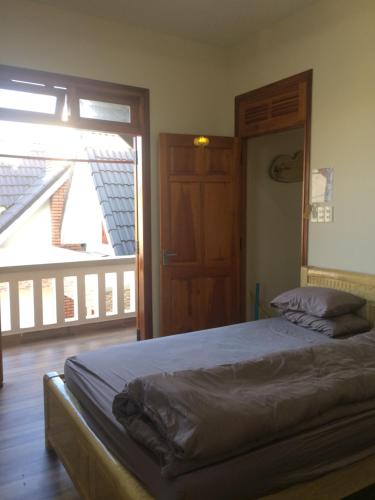 a bedroom with a bed and a door to a balcony at Anh Trang Homestay in Da Lat
