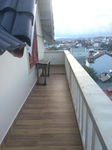 a balcony with a bench and a view of the water at Anh Trang Homestay in Da Lat