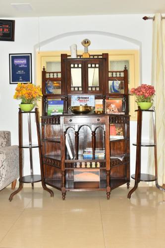 a wooden shelf with flowers in a room at KSTDC Hotel Mayura Sudarshan ,Ooty in Ooty