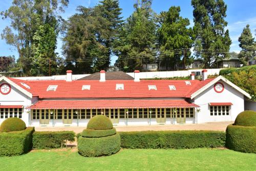 a large white building with a red roof at KSTDC Hotel Mayura Sudarshan ,Ooty in Ooty