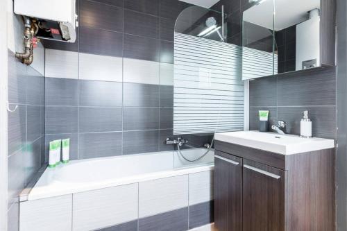 a bathroom with a tub and a sink and a mirror at Charmant appartement met zicht Damse vaart @Brugge in Bruges