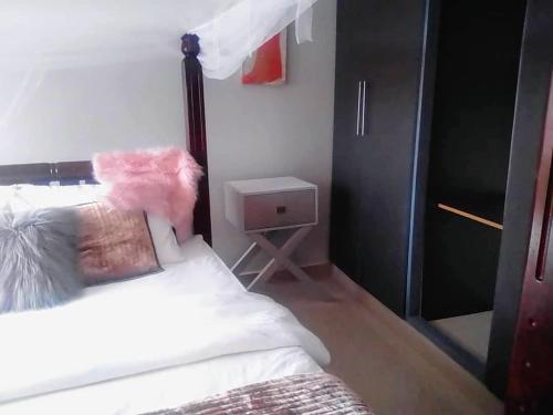 a bedroom with a bed with a black head board at Trendy apartments in Entebbe