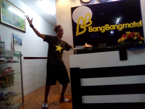 a man standing in a room with his hand in the air at BangBang Motel in Can Tho