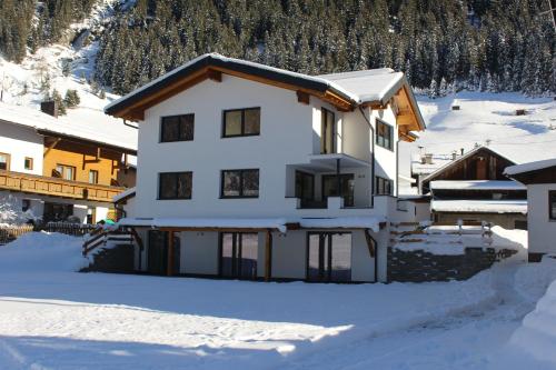 a house in the snow with snow at Apart Alpenjuwel in Sankt Leonhard im Pitztal