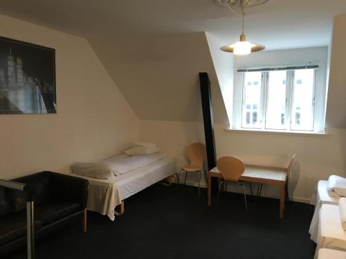 a bedroom with a bed and a table and a window at Hotel Euroglobe in Copenhagen