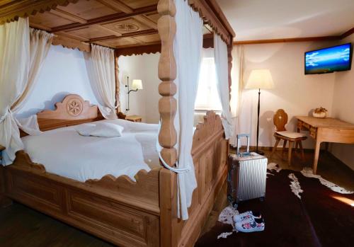 a bedroom with a large wooden bed with a canopy at Hôtel de Ville in Gruyères