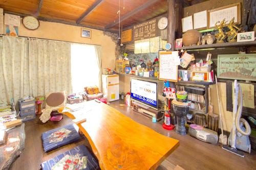 Ein voll ausgestattetes Zimmer mit einem Schreibtisch und einem Computer. in der Unterkunft Muumin Farm in Nakijin