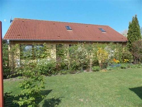 ein Backsteinhaus mit rotem Dach und Hof in der Unterkunft Ferienappartements Haus Fischersruh in Lauterbach