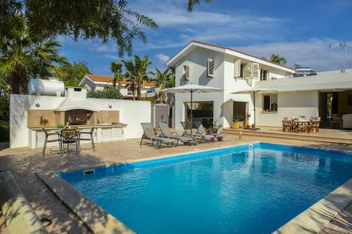 a villa with a swimming pool in front of a house at Larnaca Villa Anthea 12 in Larnaca
