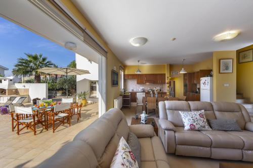 a living room with a couch and a table and a kitchen at Larnaca Villa Anthea 12 in Larnaca