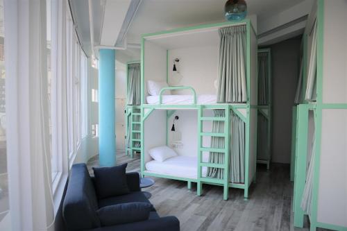 a room with bunk beds and a couch at TG Hostel - stay together in Taichung