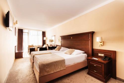 une chambre d'hôtel avec un grand lit et un salon dans l'établissement Grand Hotel Neum Wellness & Spa, à Neum