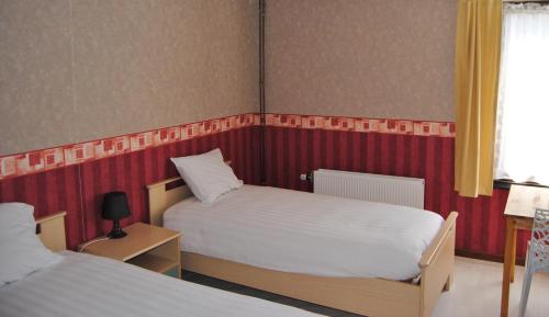 a small bedroom with two beds and a window at Hotel Beco in Banneux