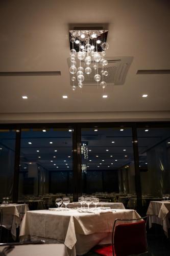 a dining room with white tables and a chandelier at Waldorf Palace Hotel in Cattolica