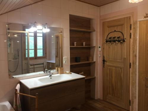La salle de bains est pourvue d'un lavabo et d'un miroir. dans l'établissement CHALET Les Chouchous, à Passy