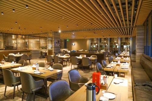 a dining room with tables and chairs and a restaurant at Fulitai International Hotel in Yantai