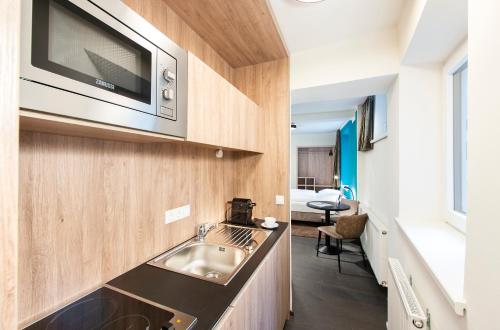 a kitchen with a sink and a microwave at Blackhome Innsbruck Boutique I contactless check-in in Innsbruck