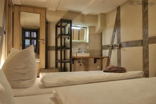 クヴェードリンブルクにあるHostel & Hotel Samoccaのベッドルーム1室(ベッド2台、シンク、鏡付)