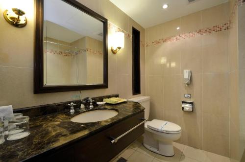 bagno con lavandino, servizi igienici e specchio di Hotel RegaLees a Tamsui