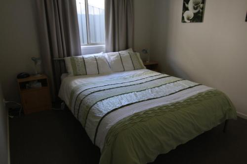 a bed in a small room with a window at 19 Georgian Court in Bright