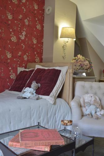 a bedroom with a bed and a couch and teddy bears at Hôtel Saint Pierre Boutique-Hôtel in Saumur