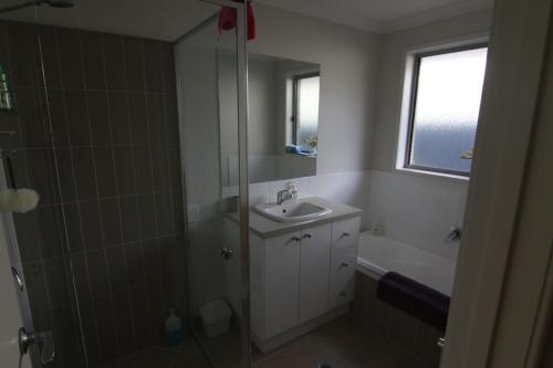 a bathroom with a shower and a sink and a bath tub at 19 Georgian Court in Bright