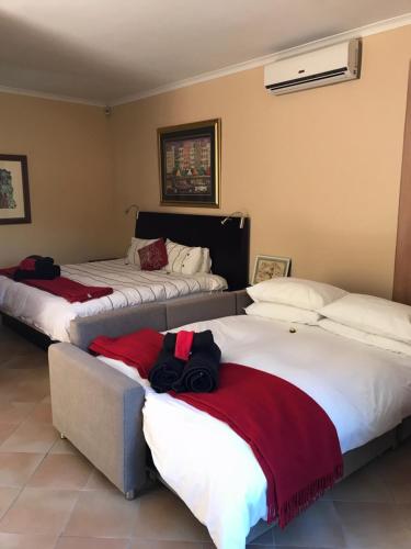 two beds in a hotel room with two bags on them at Wine Cottage by the Sea in Helderberg