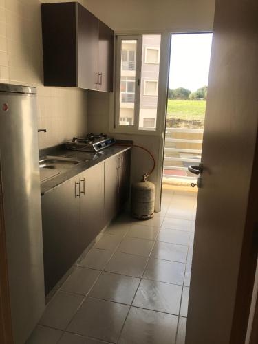 a kitchen with white cabinets and a door to a window at Love House Tanger in Tangier