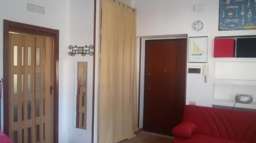 a living room with a red couch and a door at Casa Panorama Amalfi Coast in Vietri sul Mare