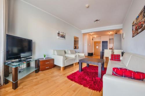 a living room with white furniture and a flat screen tv at Casa Marina, Sun & Snow in Świnoujście