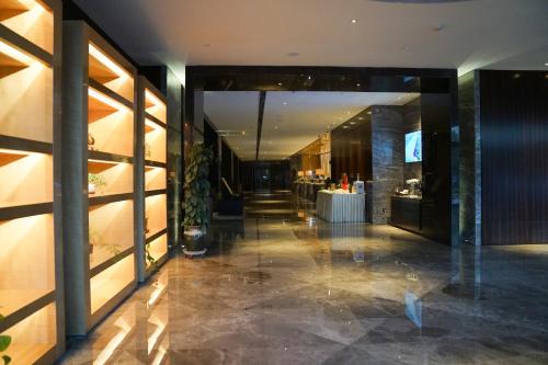 a lobby of a hotel with a table in it at Yantai Meiya International ApartHotel (Previous Ramada Plaza) in Yantai